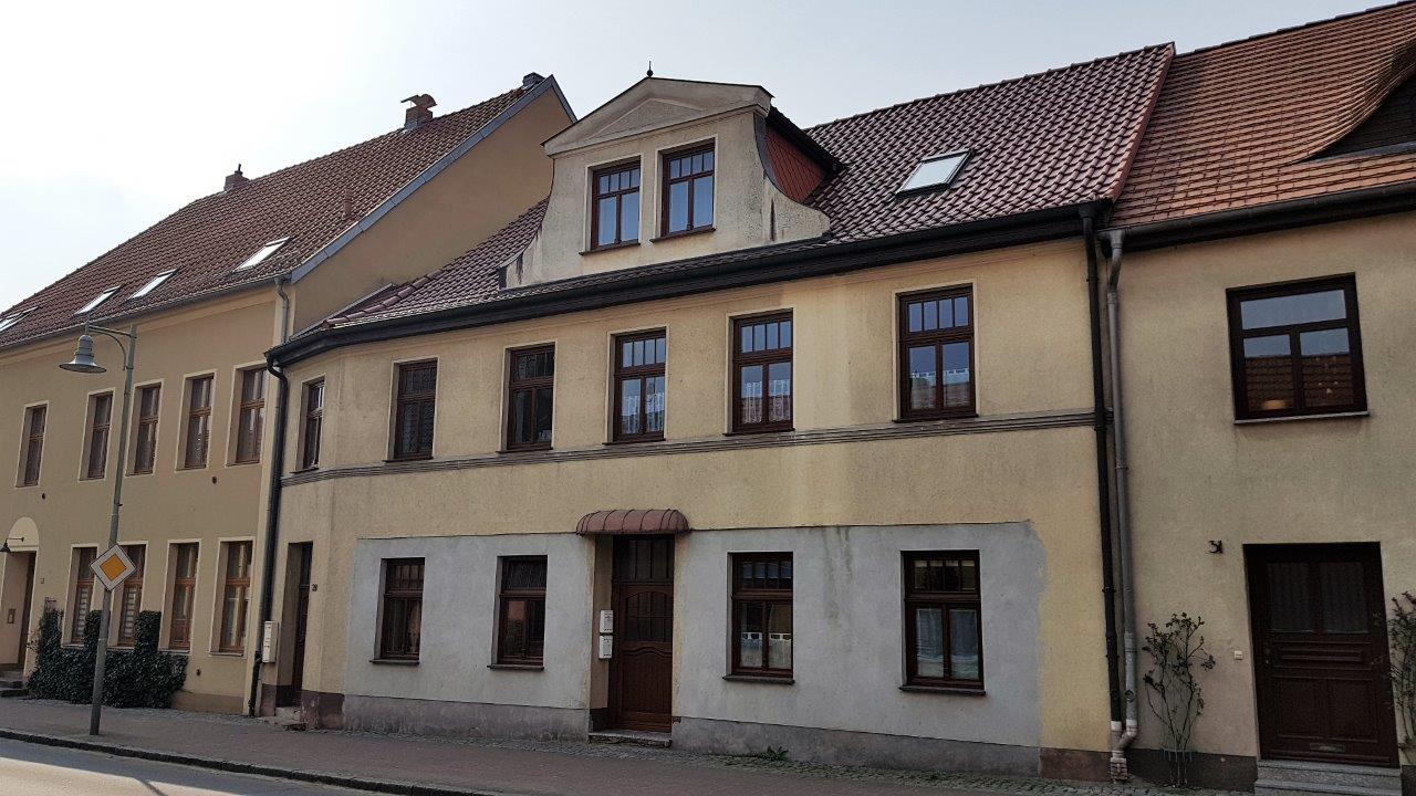 Straßenansicht eines Mehrfamilienhauses mit rotem Ziegeldach in Tessin – Referenzobjekt 5639.