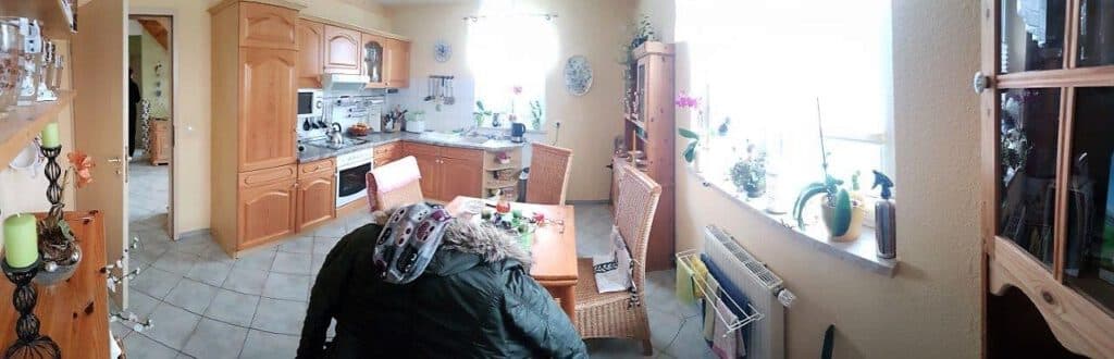 Geräumige Wohnküche mit Echtholz-Einbauküche, Essplatz und Fliesenboden in einem Reihenendhaus in Ribnitz-Damgarten