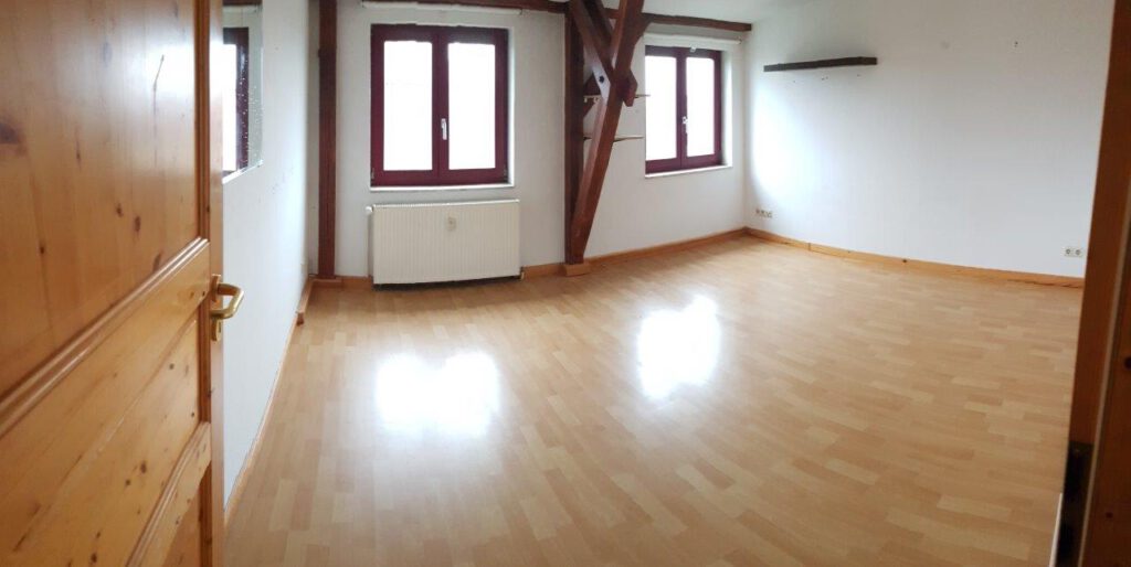 Wohnraum der Dachgeschosswohnung in der Rostocker KTV mit sichtbarem Fachwerk und Holzbalken – Referenzobjekt 5580 – Büchel Immobilien Rostock