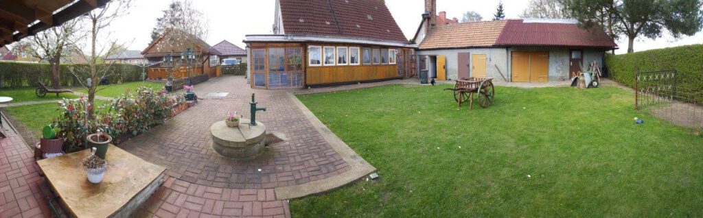 Hofansicht mit Garten, Brunnen und Nebengebäuden des Einfamilienhauses in Dolgen am See – Referenzobjekt 5499 – Büchel Immobilien Rostock